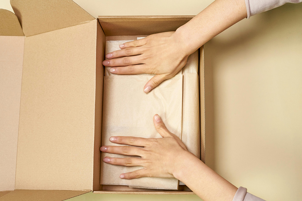 Books being packaged in a cardboard box, ready for shipping