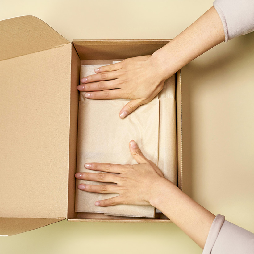 Books being packaged in a cardboard box, ready for shipping